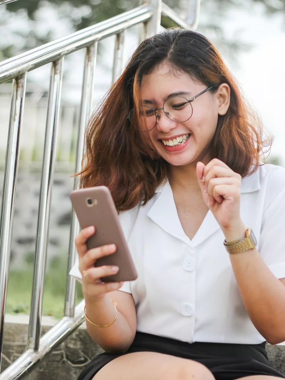 Femme souriante qui consulte les réseaux sociaux sur son téléphone